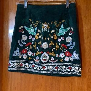 Corduroy mini skirt with floral stitching.